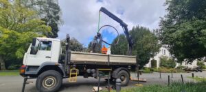 Delivery of bronze Red Ribbon sculpture from back of a crane lorry