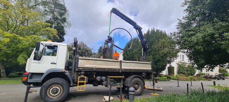 Delivery of bronze Red Ribbon sculpture from back of a crane lorry